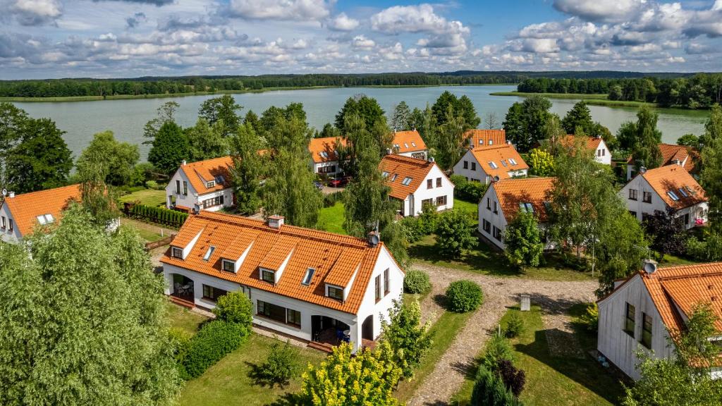 - une vue aérienne sur une ville avec une rivière et des maisons dans l'établissement Domy przy Jeziorze Sun & Snow Osada Zamkowa, à Pasym