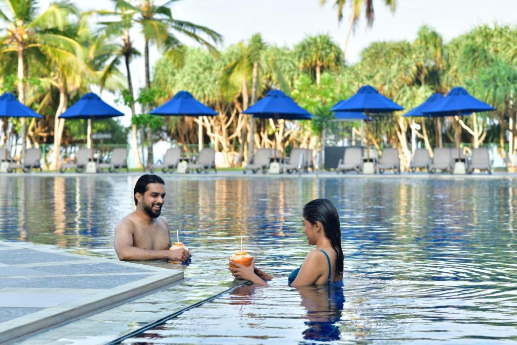 mężczyzna i kobieta w basenie w obiekcie Sheraton Kosgoda Turtle Beach Resort w mieście Bentota
