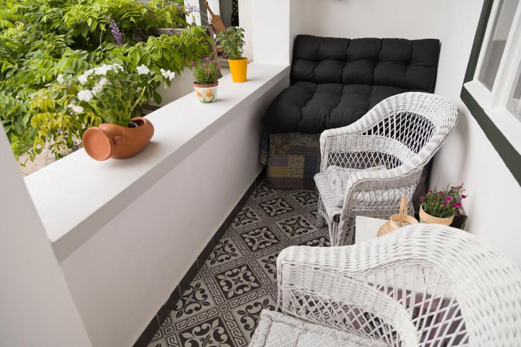 uma varanda com cadeiras de vime e um sofá em Kurucz Apartman em Sárospatak