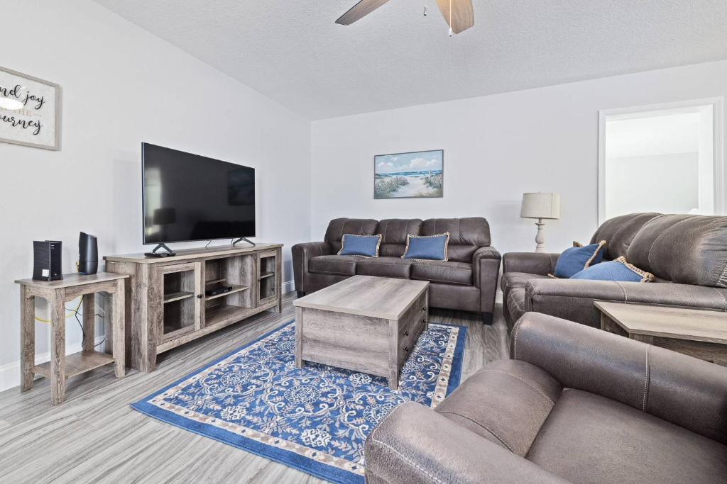 a living room with couches and a flat screen tv at Nature's Coast Retreat in Spring Hill