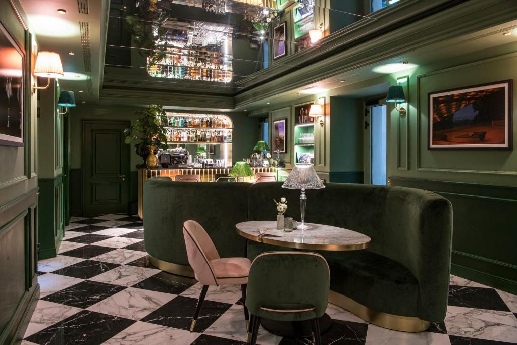 a bar with green walls and a table and chairs at Hotel La Gemma in Florence