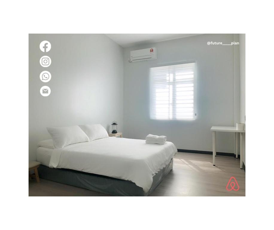 een witte slaapkamer met een bed en een raam bij Future Plan Airbnb in Tawau