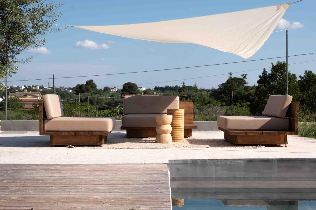 a group of reclining chairs sitting under a tent at Alloggio nei Trulli della Masseria Collina Casanoja in Noci
