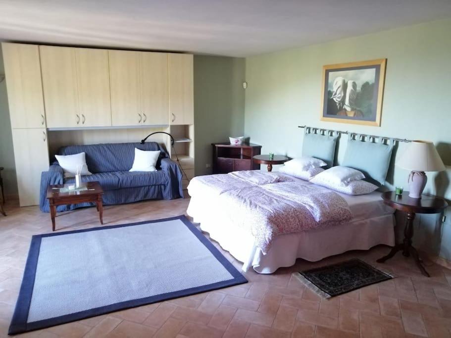 Vallebona的住宿－Casa dell'Ulivo da Lisa e Alessio008062-LT-0023，一间卧室配有一张床和一张蓝色的沙发