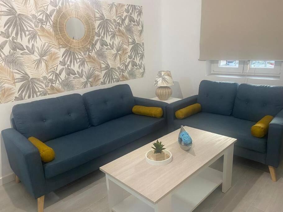 sala de estar con sofá azul y mesa en Apartamento en Toledo ideal para visitas a Puy du Fou, en Toledo