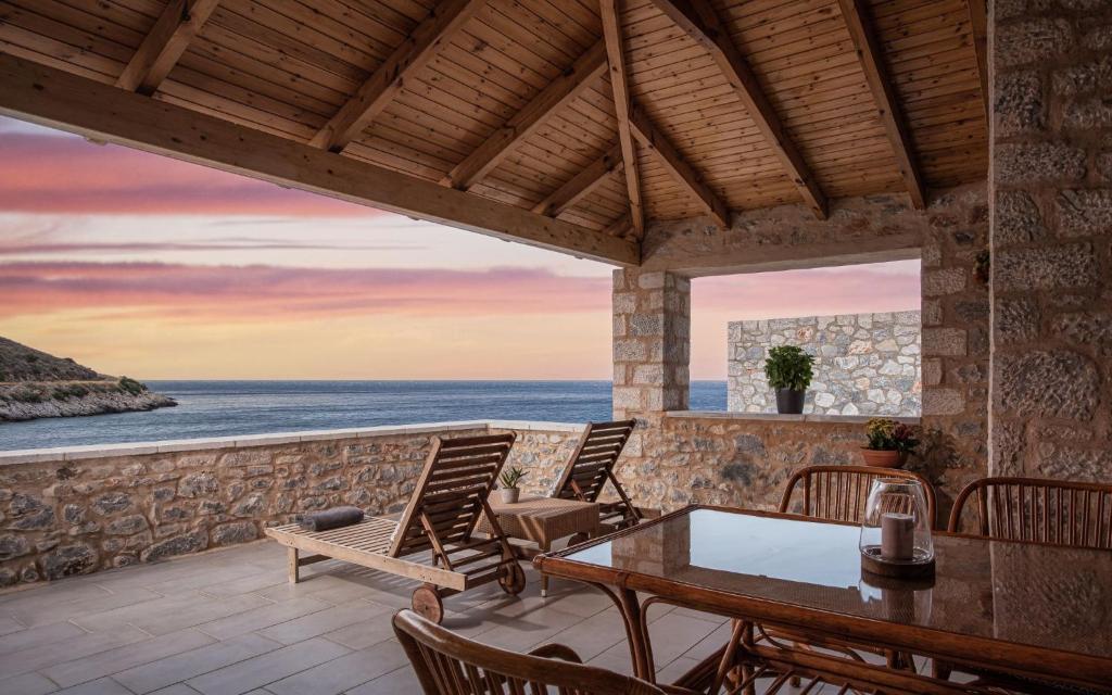 a patio with a table and chairs and the ocean at K Waterfront Residence In Mani in Áyios Kiprianós