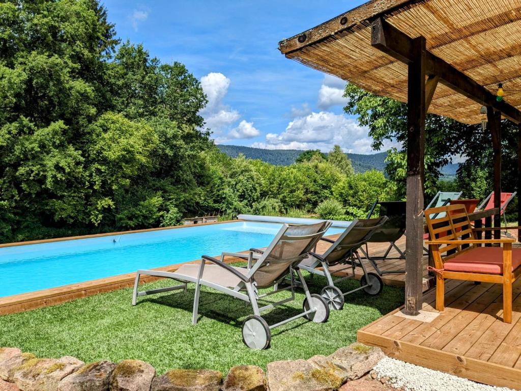 a pool with two lounge chairs and a gazebo at Gîtes Le Verger in Taintrux