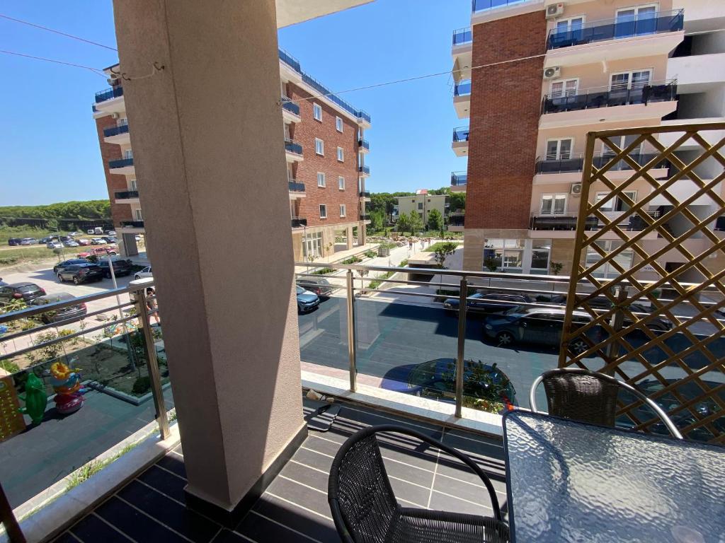 a balcony with chairs and a view of a street at Apartment Ferizaj in Velipojë