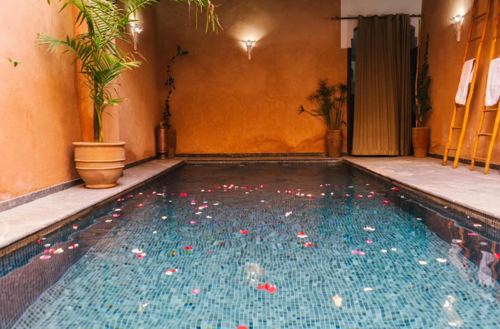 a swimming pool with red peppers in the water at Palais Aix Kabaj &Spa in Marrakech