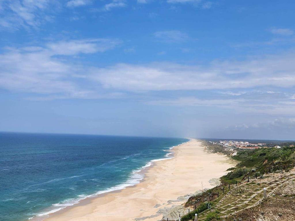 een uitzicht op een strand met de oceaan bij Casa dos Patos Quiaios in Figueira da Foz