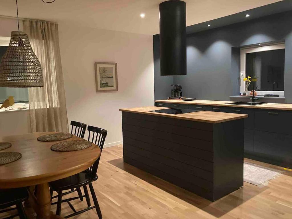 a kitchen with a wooden table and a kitchen with a stove at Enkelheten i Kivik in Kivik