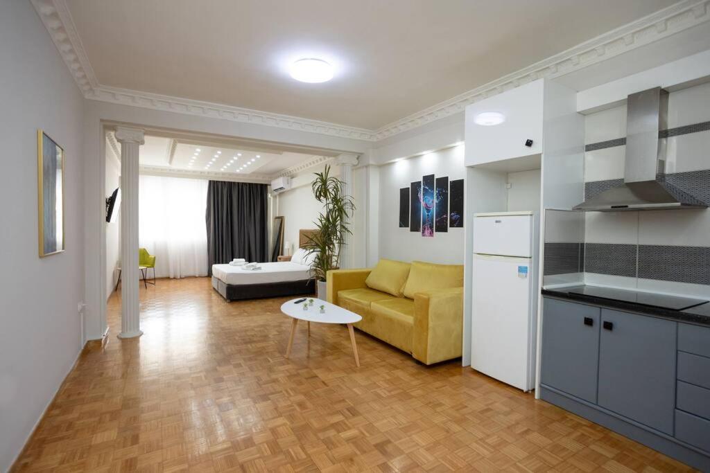a kitchen and a living room with a yellow couch at Hestia Apartment! in Thessaloniki