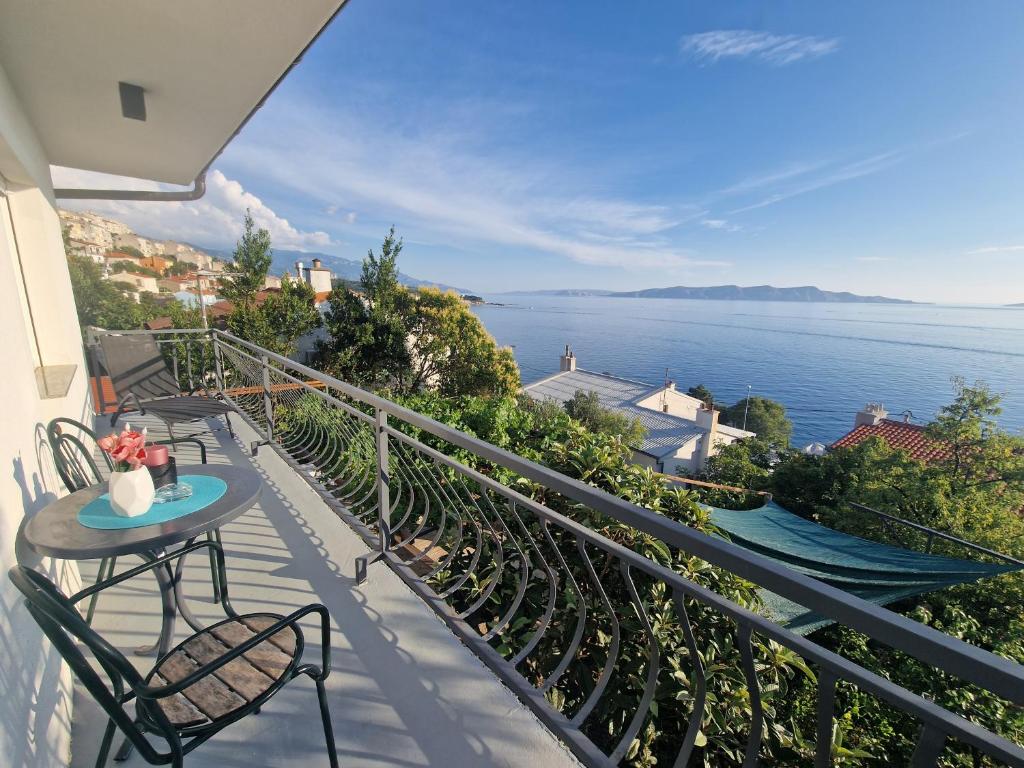 a balcony with a table and chairs and the ocean at Villa Biondina in Senj