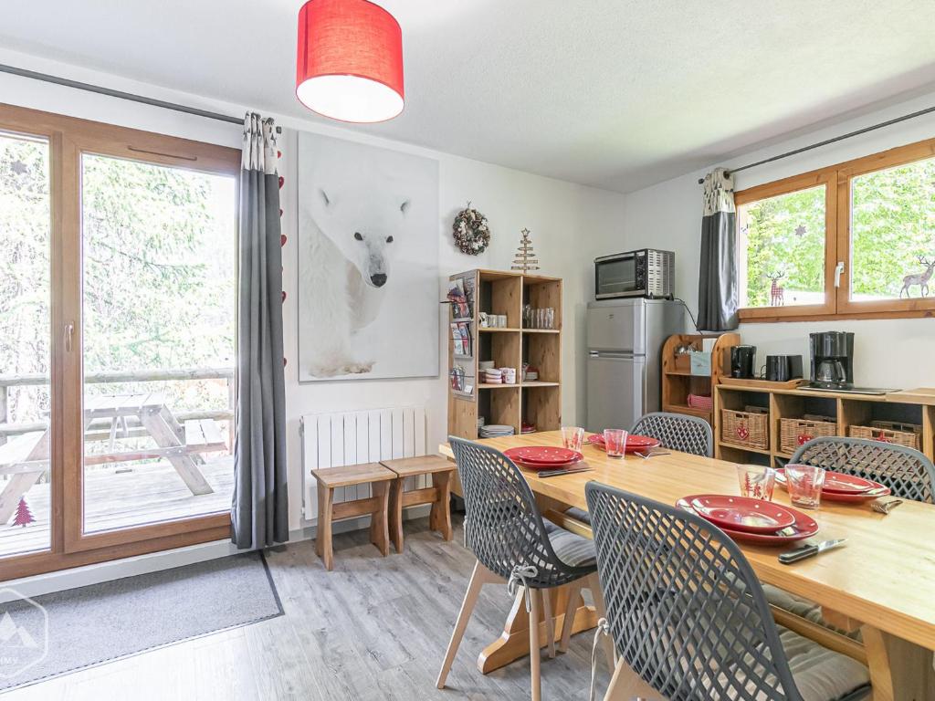 une cuisine et une salle à manger avec une table et des chaises en bois dans l'établissement Magnifique T3 rénové 4-6 pers avec terrasse, pied des pistes, wifi gratuit, équipements complets - FR-1-265-165, à Valfréjus
