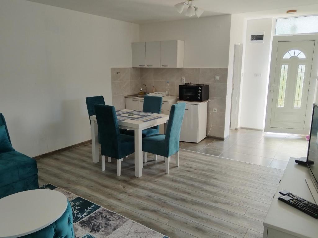 a kitchen and dining room with a table and chairs at Stari Hrast 1 in Prolomska Banja