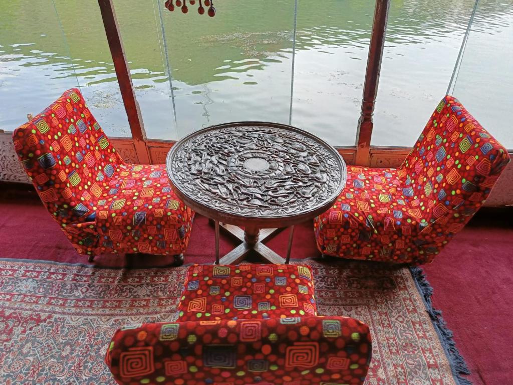 a table and two chairs and a table and some water at Hotel Island in Srinagar