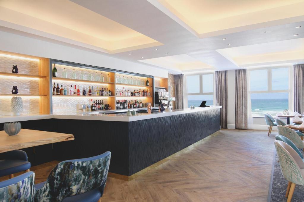 a bar in a restaurant with a view of the ocean at Esplanade Hotel in Newquay
