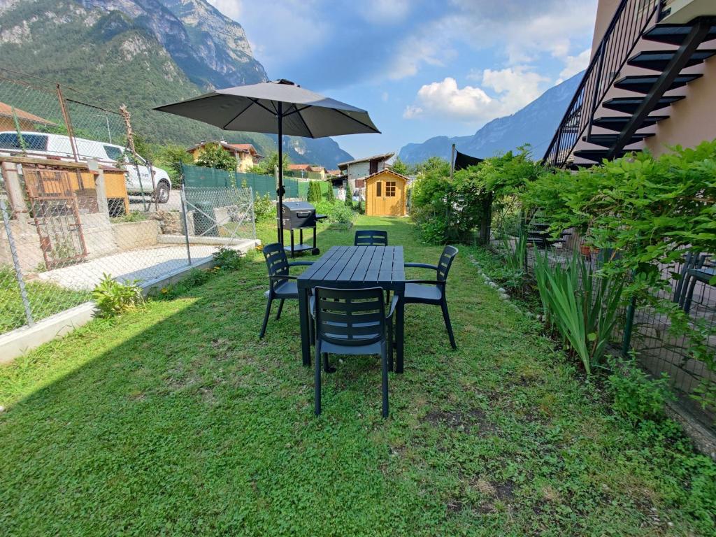 einen Tisch und Stühle mit einem Regenschirm im Gras in der Unterkunft Casa Venere in Ospedaletto