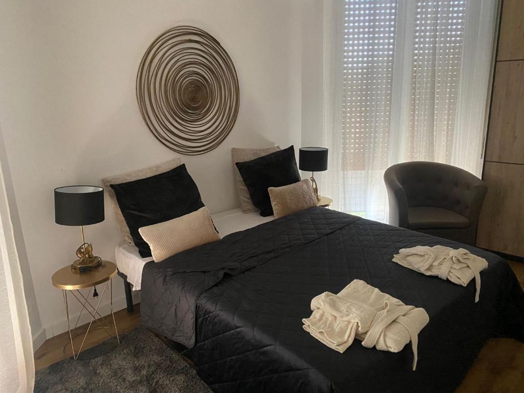 a bedroom with a large black bed and a chair at Eur Centro lux apartment con camino in Rome