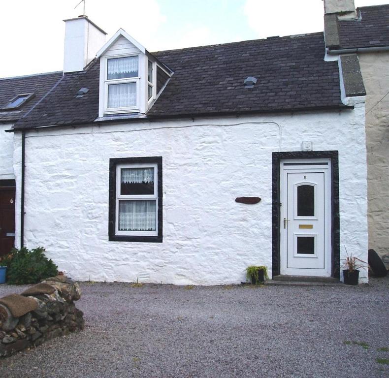 a white house with a white door and windows at Ailsa Cottage in Newton Stewart