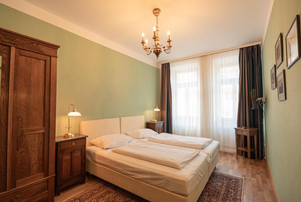 Un dormitorio con una cama grande y una lámpara de araña. en Pension Bellevue, en Múnich