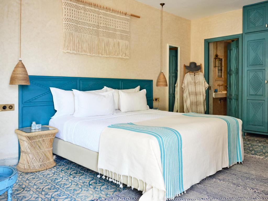 a bedroom with a large bed with a blue headboard at Dar Jasmine in Chefchaouene