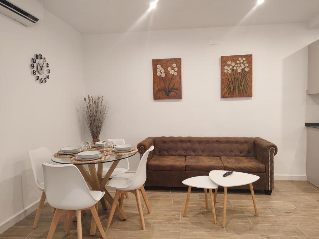 - un salon avec un canapé, une table et des chaises dans l'établissement Apartamento Inés y Manolo, à Cordoue