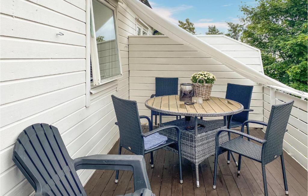 uma mesa de madeira e cadeiras num alpendre com uma mesa em Gorgeous Apartment In lesund With House A Panoramic View em Ålesund