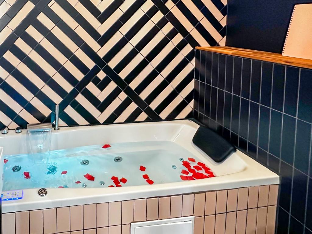 uma banheira de hidromassagem numa casa de banho em azulejo em Flamant Rose em Annecy