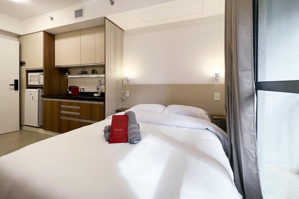 1 dormitorio con 2 camas y una maleta roja en la cama en Zainalofts7 Moema - 1km Ibira e 200m metrô 507 ID, en São Paulo