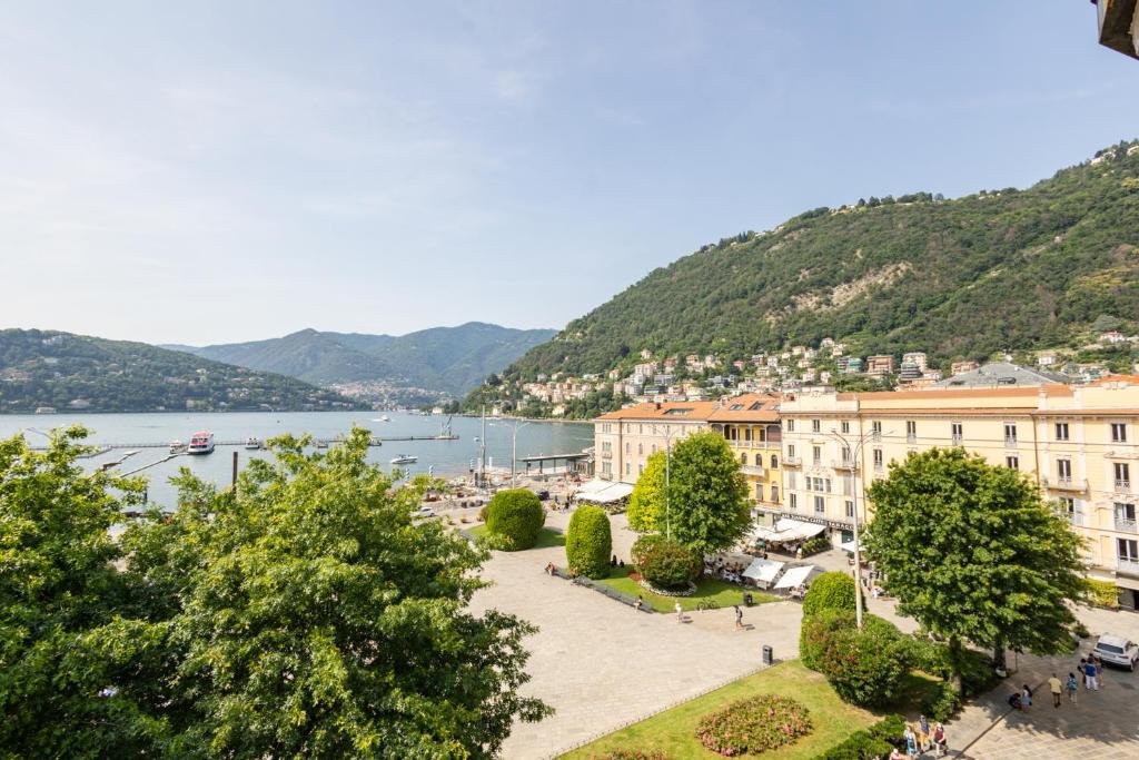 a view of a town with a lake and mountains at Piazza Cavour Lake View - by MyHomeInComo in Como