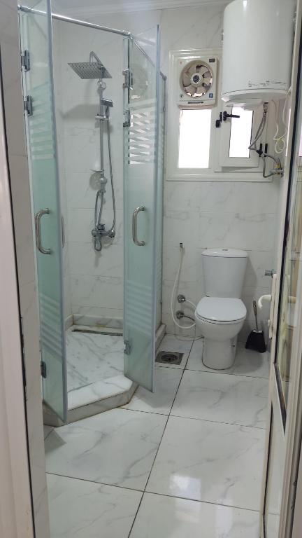 een badkamer met een douche en een toilet bij المعموره الشاطيء in Alexandrië