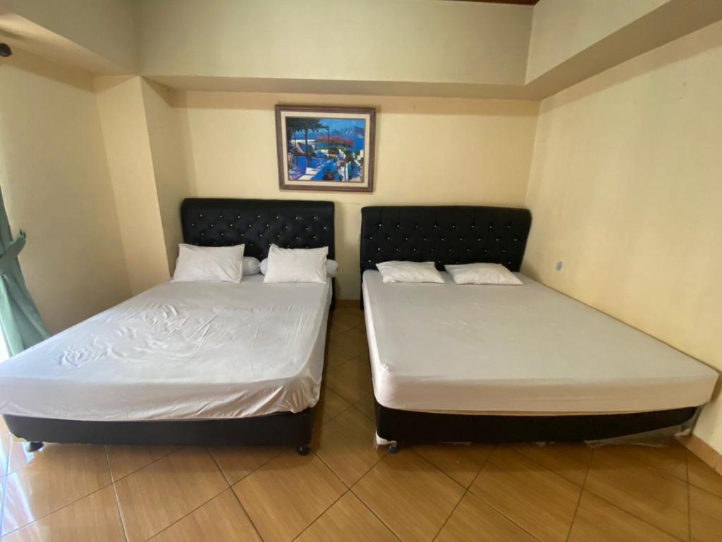 two beds sitting next to each other in a room at Apartment Marbella Anyer in Serang