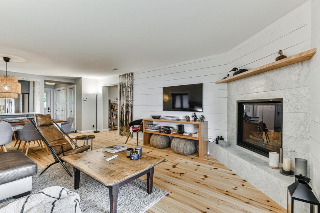 sala de estar con chimenea y mesa en 454 Hotel du Lac - Cozy 2BR Condo w Stunning Mountain & Lake Views, en Mont-Tremblant