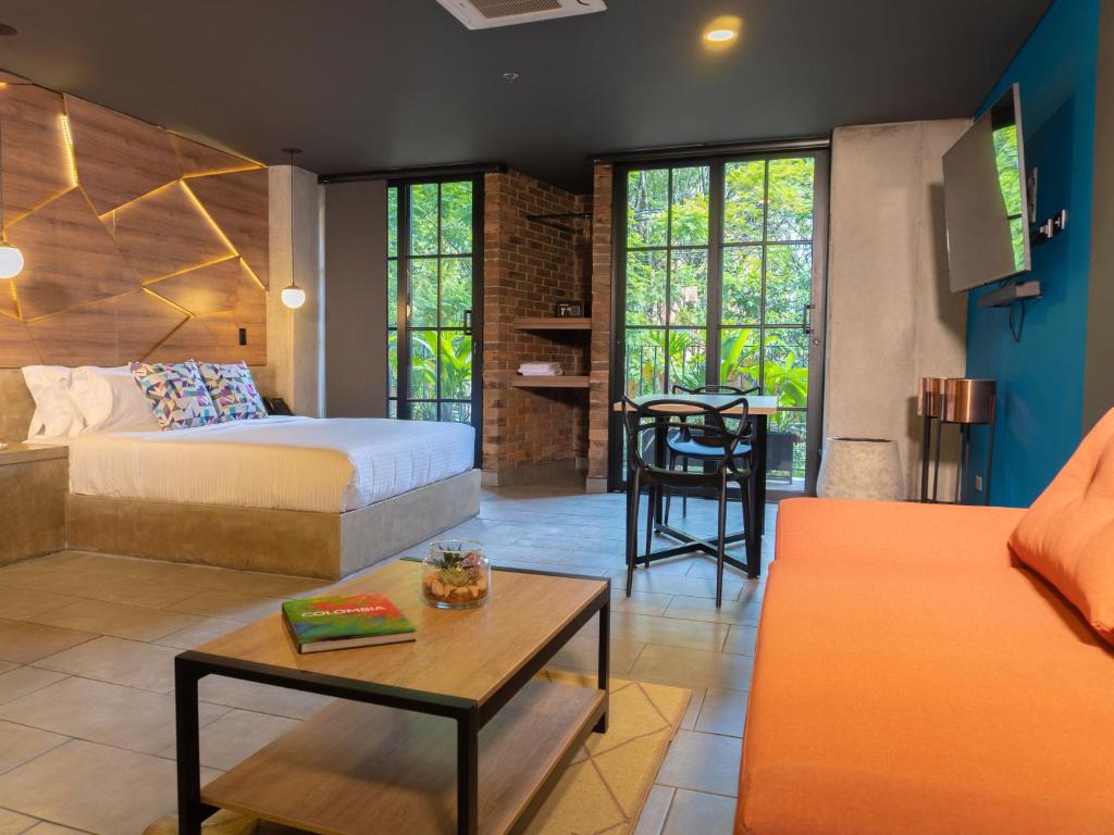 a bedroom with a bed and a living room with a table at Los Patios Cool Living in Medellín