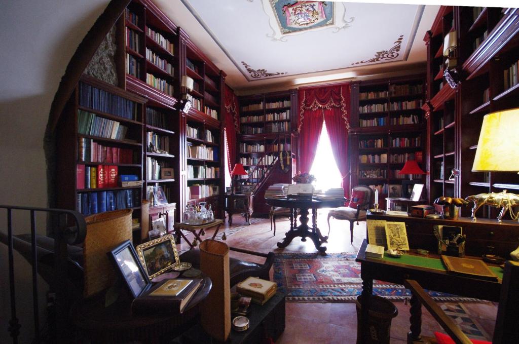 Palazzo Lupis B & B Grotteria Calabria Italia في Grotteria: مكتبة غرفة مليئة بالكتب
