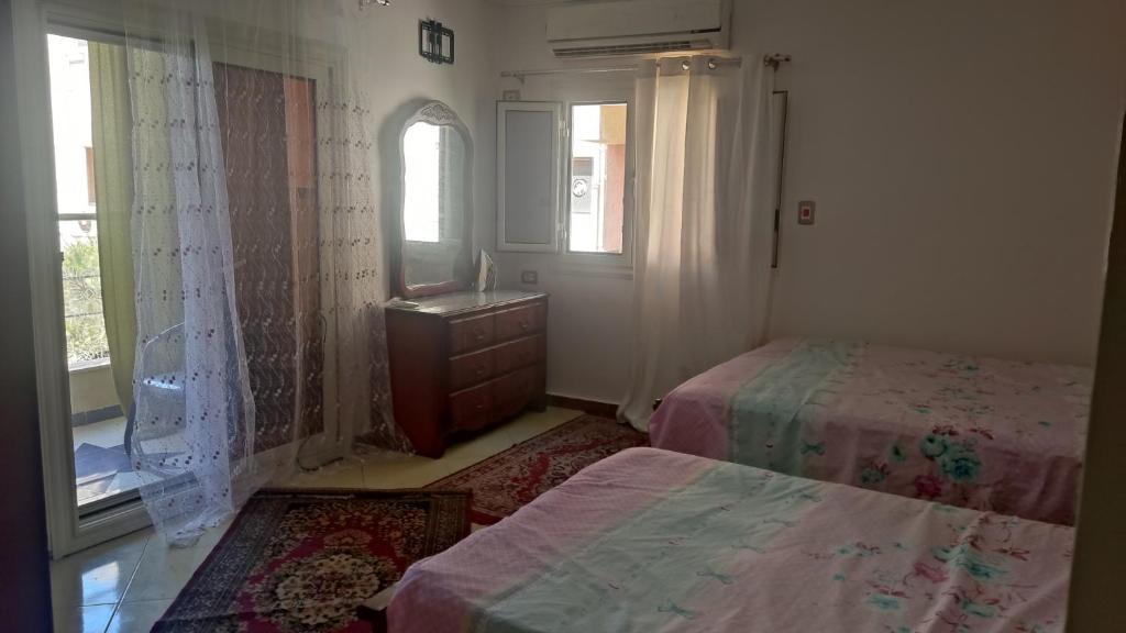 a bedroom with two beds and a window at المعمورة الشاطىء in Alexandria