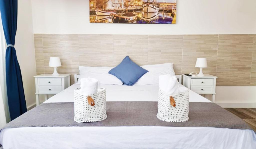 una camera con un letto bianco con due comodini di RiminiMare House a Rimini