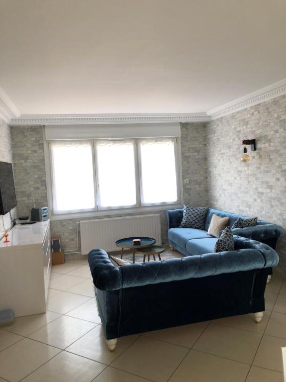 un salon avec un canapé et une table dans l'établissement Maison de ville proche de la mer, à Le Portel