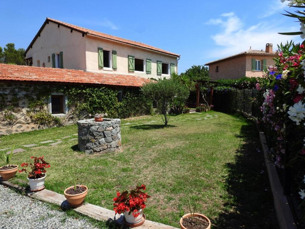 un jardin avec des plantes en pot en face d'une maison dans l'établissement La bergerie de vaulongue a 3km de la mer mediterranee, à Saint-Raphaël