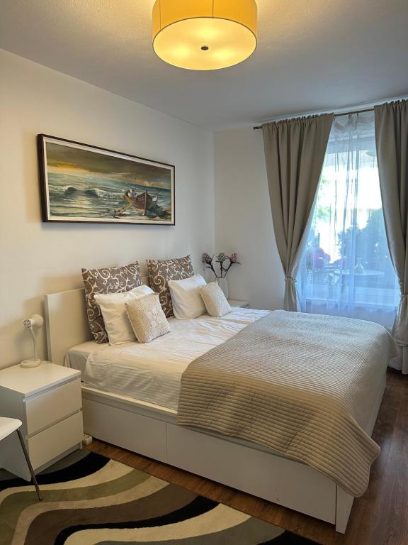 Un dormitorio con una cama grande y una ventana en Biliūno g. 5 apartamentas 1-am aukšte su didele terasa, en Palanga
