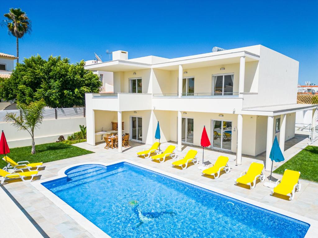 a villa with a swimming pool in front of a house at Villa Impasse - Albufeira in Albufeira