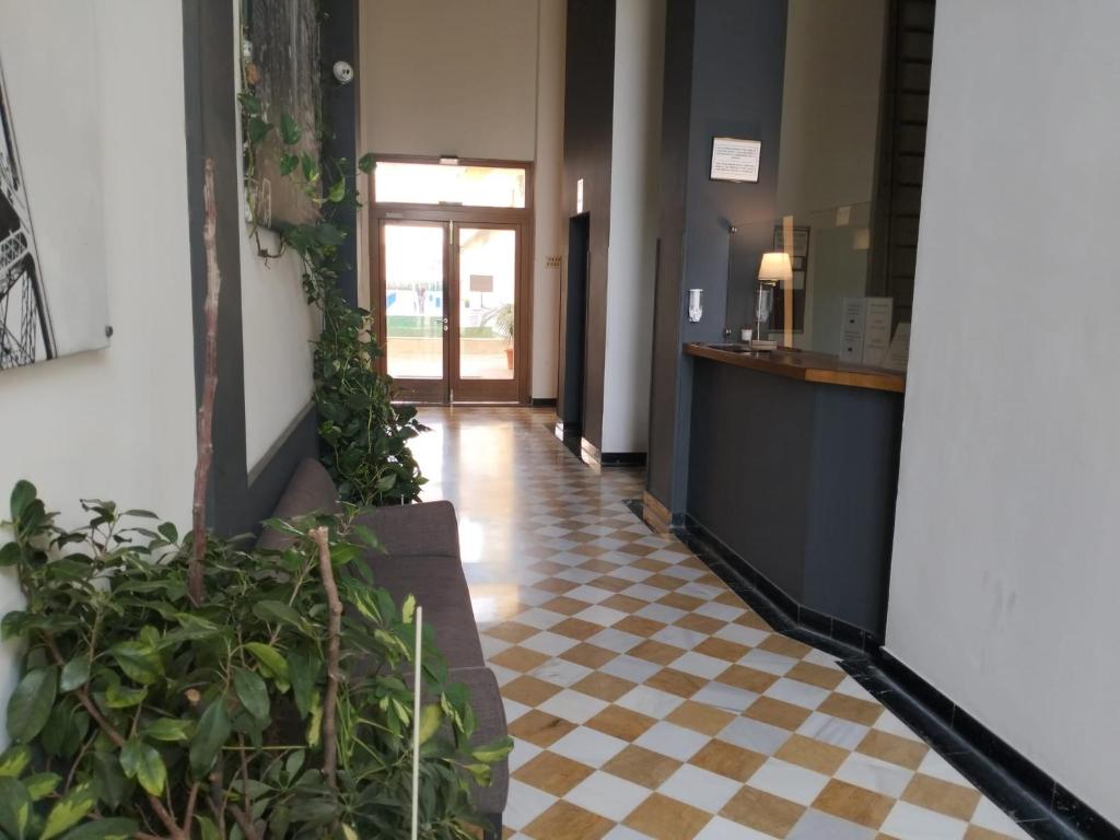 a hallway with a checkered floor and plants at Estudio Fibes-Lux Sevilla in Seville