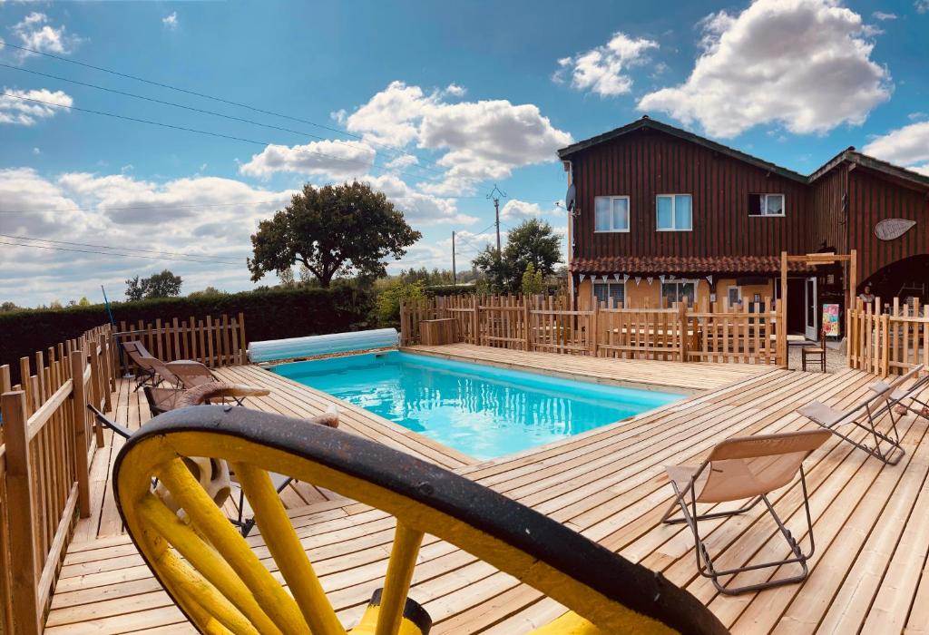 una terraza de madera con piscina y una casa en Camping Syl-Vallée Western Village, en Bouglon