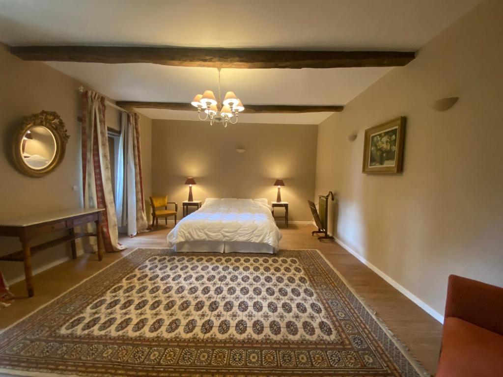 Schlafzimmer mit einem Bett und einem Kronleuchter in der Unterkunft Pavillon d’entrée du château de Bouesse in Bouesse