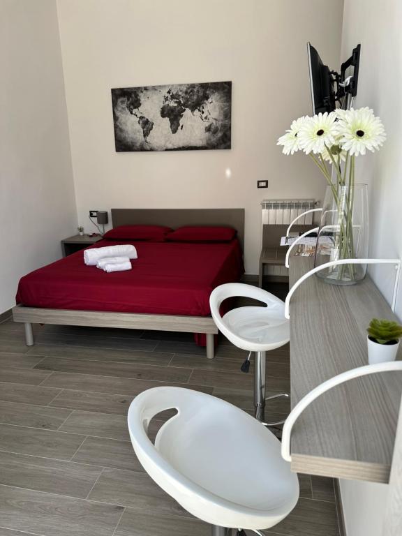 een slaapkamer met een rood bed en een tafel en stoelen bij Di Vaio’s Apartments in Napels