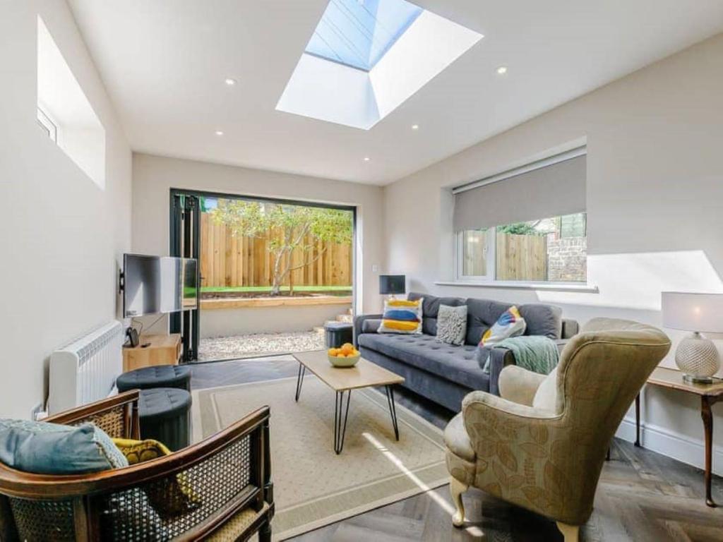 a living room with a blue couch and a window at Walpole BACK House sleeps 6-8 in Margate