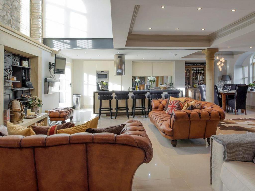 a large living room with couches and a kitchen at Old Chapel House in Barnoldswick
