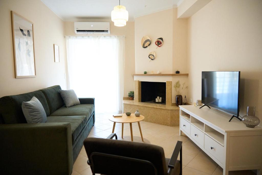 een woonkamer met een bank en een flatscreen-tv bij ILOS APARTMENT in Nafplio