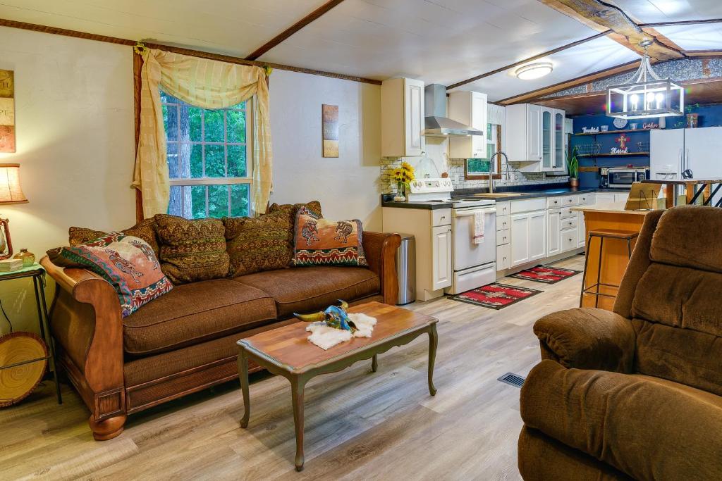 ein Wohnzimmer mit einem Sofa und einem Tisch sowie eine Küche in der Unterkunft New Concord Vacation Rental Near Kentucky Lake in New Concord